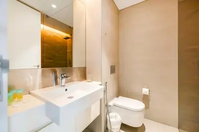 a bathroom with a white sink and a toilet at FAM Living Bluewaters - Island Living - Ain Dubai & Sea View in Dubai