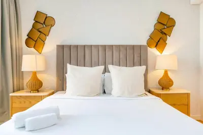 a bedroom with a large white bed with two lamps at FAM Living Bluewaters - Island Living - Ain Dubai & Sea View in Dubai