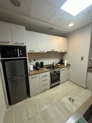 a kitchen with stainless steel appliances and white cabinets at Magic waves holiday in Dubai