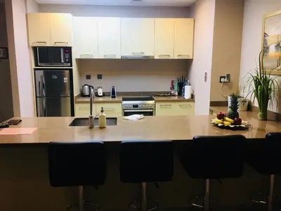 a kitchen with a counter with chairs in it at Magic waves holiday in Dubai