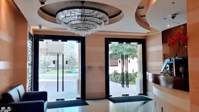 a lobby with a large chandelier and glass doors at Magic waves holiday in Dubai
