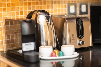 a coffeemaker sitting on a counter with coffee cups at Prime Retreats - Downtown Dubai in Dubai