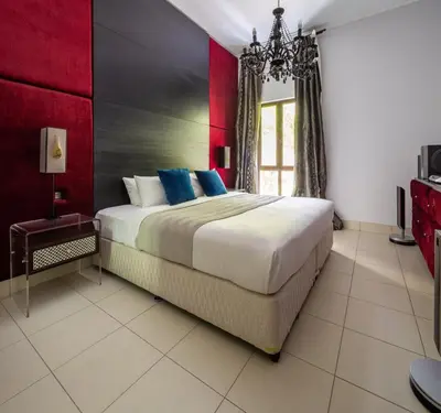 a bedroom with a large bed with blue pillows at Frank Porter - Reehan 5 in Dubai