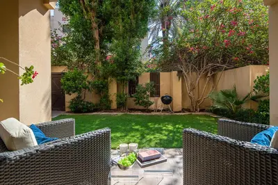a patio with two chairs and a table in a yard at Frank Porter - Reehan 5 in Dubai