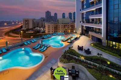 a view of a building with two swimming pools at Millennium Place Barsha Heights Hotel in Dubai
