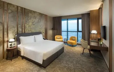 a hotel room with a bed and a desk and chair at Millennium Place Barsha Heights Hotel in Dubai