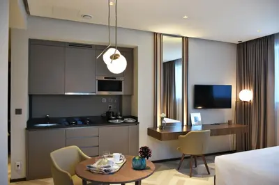 a kitchen and living room with a table and chairs at Millennium Place Barsha Heights Hotel Apartments in Dubai