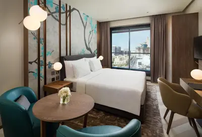 a hotel room with a bed and a table and chairs at Millennium Place Barsha Heights Hotel Apartments in Dubai