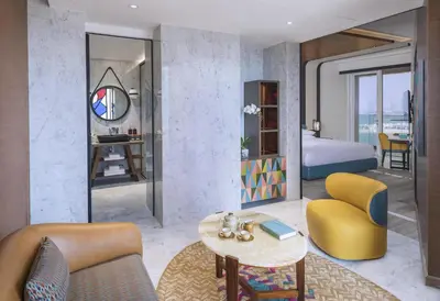 a living room with a bed and a room with a table at Andaz Dubai The Palm, By Hyatt in Dubai