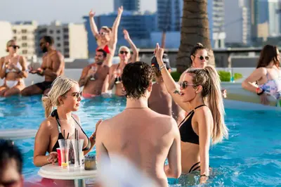 a group of people sitting in a swimming pool at FIVE Jumeirah Village in Dubai