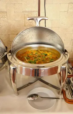 a pot of food with a spoon on a counter at Green House Hotel Suites & Apartment in Dubai
