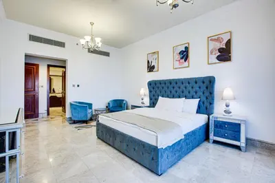 a bedroom with a blue bed in a room at South & North Residence Palm Jumeirah in Dubai