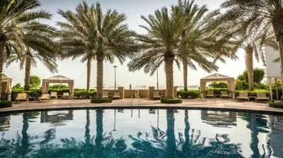 a swimming pool with palm trees in a resort at South & North Residence Palm Jumeirah in Dubai