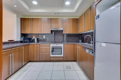 a kitchen with wooden cabinets and a refrigerator at South & North Residence Palm Jumeirah in Dubai