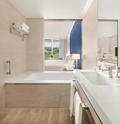 a bathroom with a large white tub and a sink at JA Lake View Hotel, Dubai in Dubai