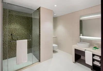 a bathroom with a shower and a sink and a toilet at Hyatt Place Dubai Jumeirah Residences in Dubai