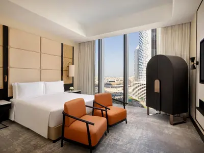 a hotel room with a bed and two chairs at Anantara Downtown Dubai in Dubai
