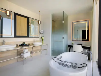 a bathroom with a tub and two sinks and a shower at Anantara Downtown Dubai in Dubai