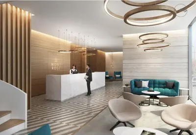 a lobby with a man standing at a counter at Millennium Executive Apartments Mont Rose in Dubai