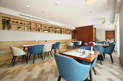 a restaurant with blue chairs and tables in it at Millennium Executive Apartments Mont Rose in Dubai