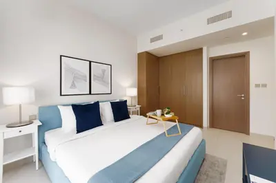 a bedroom with a large bed and a table at Maison Privee - Elevated Living with Spectacular Burj Khalifa Views in Dubai