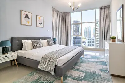 a bedroom with a large bed and a large window at Continental Tower, Dubai Marina - Luton Vacation Homes in Dubai