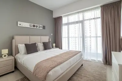a bedroom with a large bed and a large window at Continental Tower, Dubai Marina - Luton Vacation Homes in Dubai