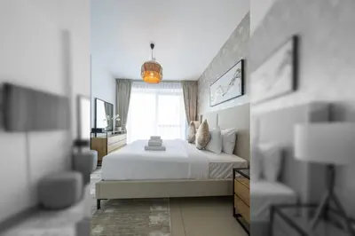 a bedroom with a white bed and a window at Spectacular 2BR with Burj Khalifa and Fountain View in Dubai