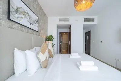a bedroom with a white bed with white pillows at Spectacular 2BR with Burj Khalifa and Fountain View in Dubai