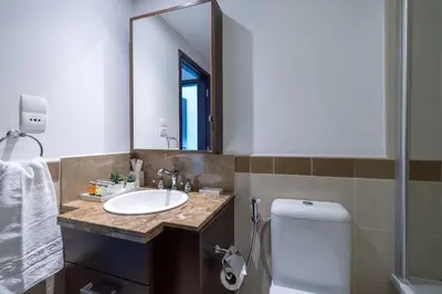 a bathroom with a sink and a mirror and a toilet at Spectacular 2BR with Burj Khalifa and Fountain View in Dubai