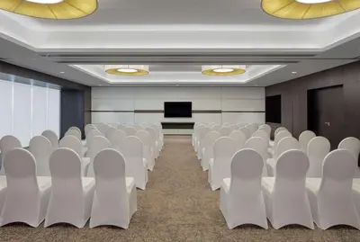 an empty conference room with white chairs and a podium at Hyatt Place Dubai Jumeirah in Dubai