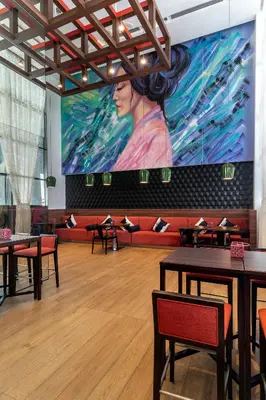 a large screen in a restaurant with tables and chairs at Hyatt Place Dubai Jumeirah in Dubai