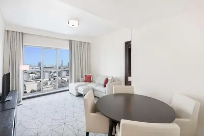 a living room with a table and chairs and a large window at Hyatt Place Dubai Jumeirah in Dubai