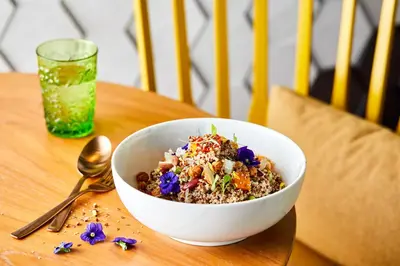 a bowl of food sitting on a table with a drink at Andaz Family Suites by Hyatt- Palm Jumeirah in Dubai