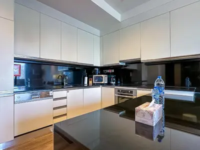a kitchen with white cabinets and a bottle of water on a counter at JW Marriott Full Marina View, Luxury Suites by Gardenia with Direct Access to Marina Mall in Dubai