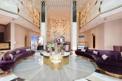 a lobby with purple couches and a table with flowers at Staycae Bay's Edge in Dubai