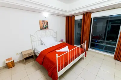 a bedroom with a bed with a red blanket at La Rivera Rooms for Ladies in Dubai