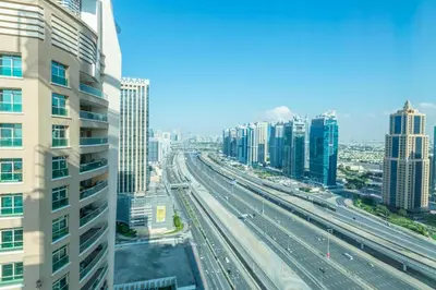 a view of a highway in a city with tall buildings at La Rivera Rooms for Ladies in Dubai
