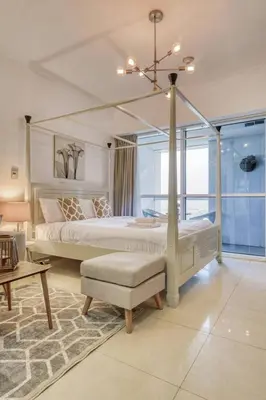 a bedroom with a canopy bed and a table at GuestReady - Modern Studio | Stunning Marina Views in Dubai