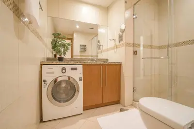a bathroom with a washing machine and a shower at GuestReady - Modern Studio | Stunning Marina Views in Dubai