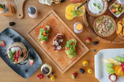 a wooden table with plates of food on it at C Central Hotel and Resort The Palm in Dubai