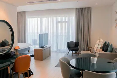 a living room with a tv and a table and chairs at C Central Hotel and Resort The Palm in Dubai