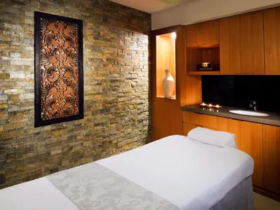 a bedroom with a bed and a brick wall at Novotel Dubai Al Barsha in Dubai