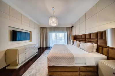 a bedroom with a large bed and a tv at Nice 2BD apartment in the Palm Jumeirah in Dubai