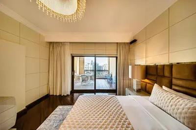 a bedroom with a large bed and a balcony at Nice 2BD apartment in the Palm Jumeirah in Dubai