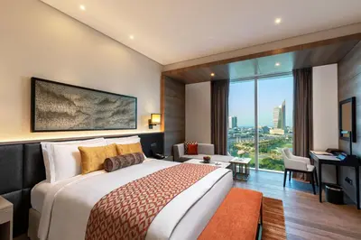 a hotel room with a large bed and a desk at Taj Jumeirah Lakes Towers in Dubai