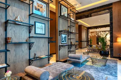 a lobby with wooden walls and a couch and chairs at Taj Jumeirah Lakes Towers in Dubai