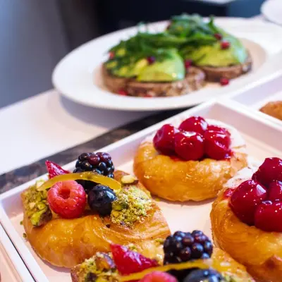 a plate of pastries with fruit on top of it at Taj Jumeirah Lakes Towers in Dubai