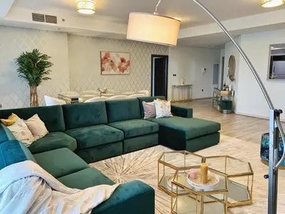 a living room with a green couch and a table at Harmony Vacation Homes - BALQIS Residence in Dubai
