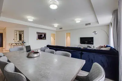 a dining room with a table and chairs and a couch at Harmony Vacation Homes - BALQIS Residence in Dubai